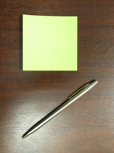 istock Pen and yellow sticker on a dark table 914993952