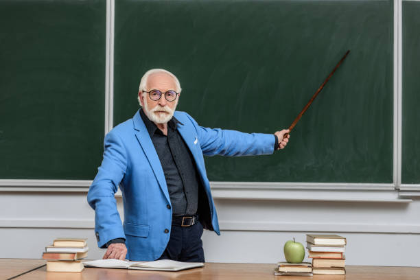 istock grey hair professor pointing on something at blackboard 914995236