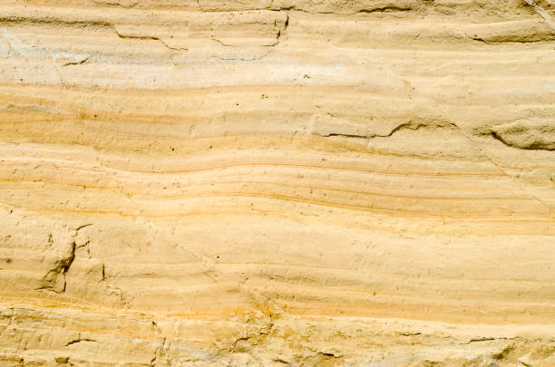 istock A yellow sandstone with cracks closeup in sunny day 915001188