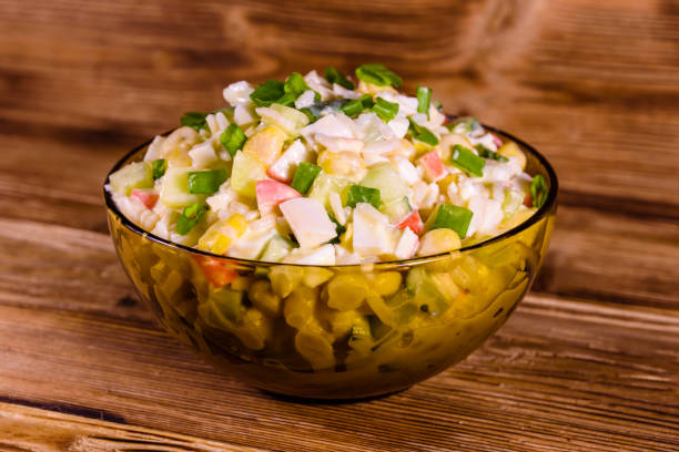 istock Glass bowl with salad from crab sticks on wooden table 915005790