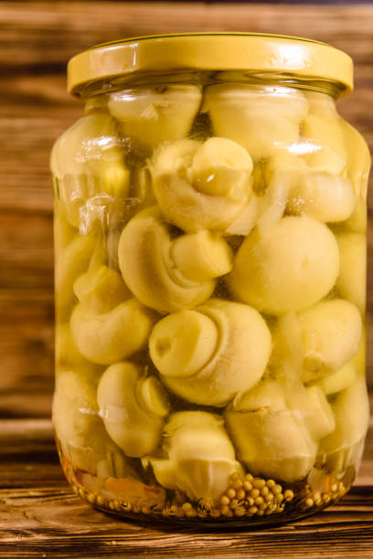 istock Jar with canned mushrooms on wooden table 915008450