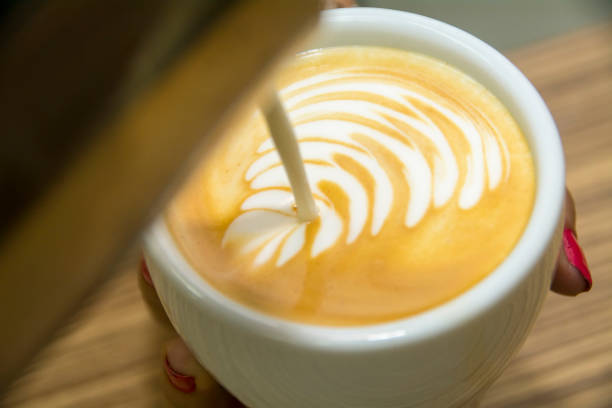 Making latte art by barista focus in milk and coffee