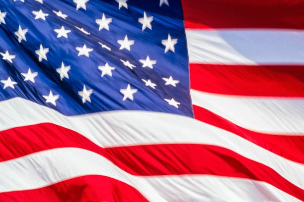 istock A USA Flag waving in the wind with slight motion blur 915008598