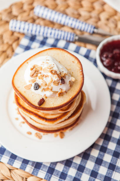 istock Pancakes stack on a white plate with cream and granola. Maslenitsa. Traditional Russian holiday.Shrove Tuesday, pancake day, 915010178
