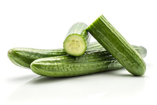 European cucumbers (burpless, seedless, hothouse, gourmet, greenhouse or English) set isolated on white background two whole and two fresh cut halves