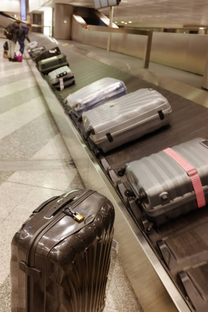 istock Black suitcase with a lock at arrivals area 915017560