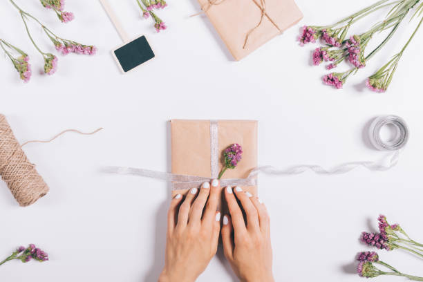 istock Packing gifts for a holiday on a white table 915017966