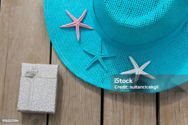 Blue Ladies Hat And Gift Package On The Table Stock Photo - Download Image Now - Arts Culture and Entertainment, Birthday, Birthday Present