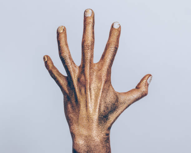 istock Female hand in gold paint 915025558