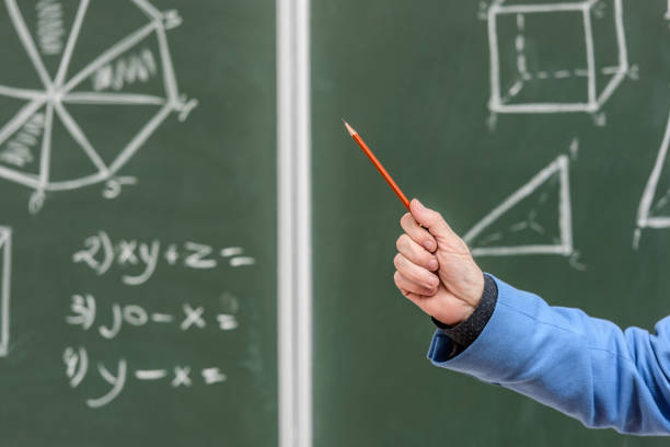 istock cropped image of senior professor pointing on something with pencil on blackboard 915028722