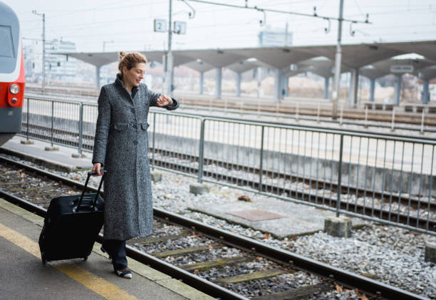 istock Business woman with a suitcase checking the time 915042214