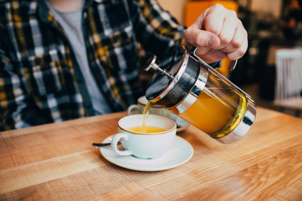 istock man fill up cup with hot tea from french press 915044680