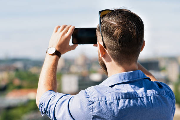 istock Young caucasian man taking photos on his mobile Lithuania 915045032