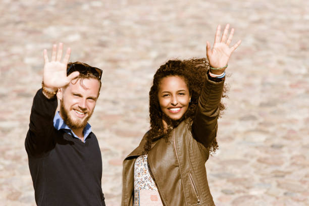 istock Young multiracial couple greeting their friends Lithuania 915045106