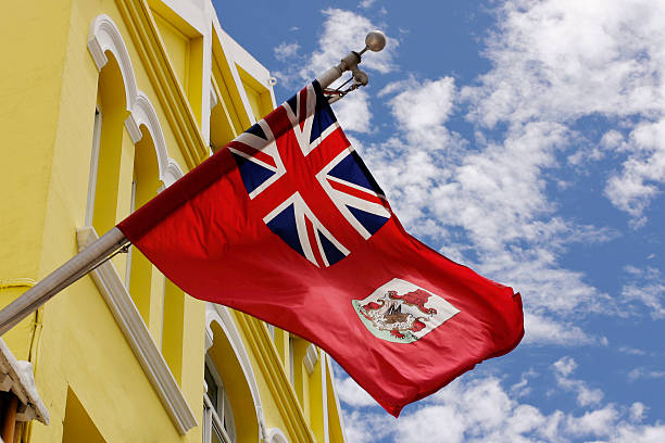 Bermuda flag hanged out on a yellow building  Bermuda flag on a beautiful Bermuda day bermuda stock pictures, royalty-free photos & images