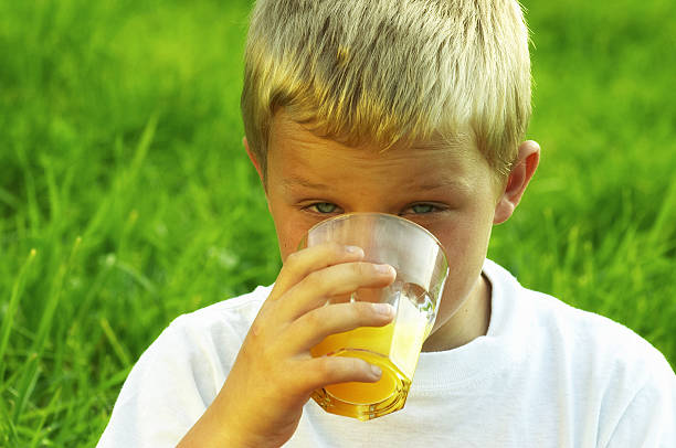istock Boy drinking a glass of orange juice 91505294
