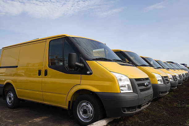 A row of bright yellow vans on a lovely day stock photo