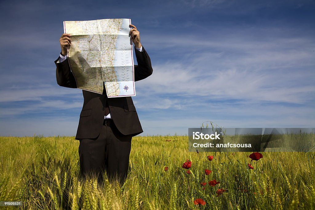 Geschäftsmann in Feld mit Karte verloren - Lizenzfrei Karte - Navigationsinstrument Stock-Foto