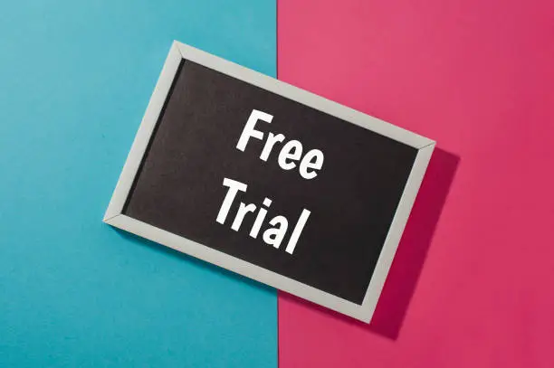 Photo of Free trial - text on chalkboard on blue and pink bright background.