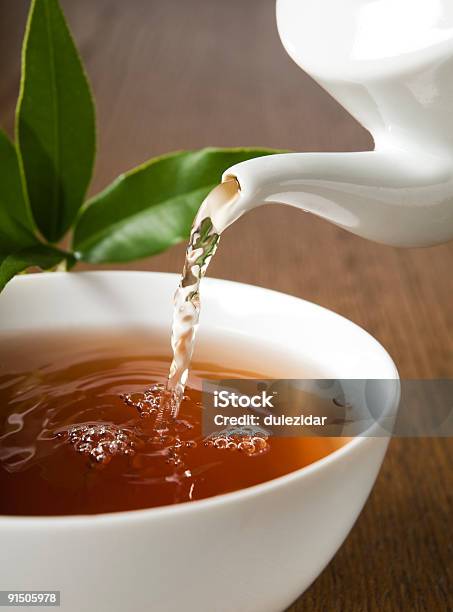 Tea Being Poured Into A Teacup Out Of A Kettle Stock Photo - Download Image Now - Breakfast, Close-up, Color Image