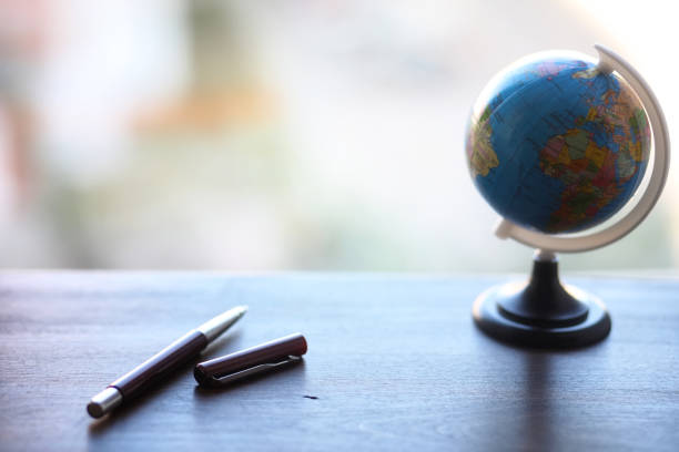 istock A pen on the desk and a small globe 915066838