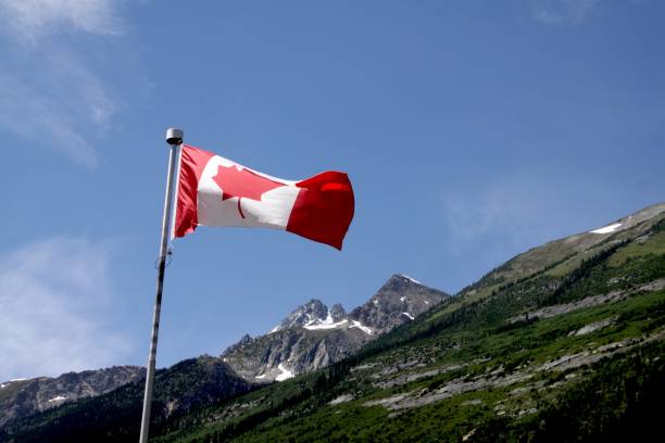 istock Canadian Flag Flying Over The Rockies 915067752