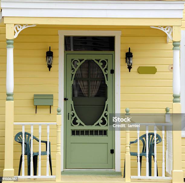Yellow Victorian Porch With Green Chairs And Green Door Stock Photo - Download Image Now