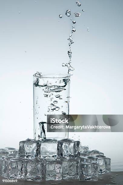 Acqua Minerale Schizzare Fuori Dal Bicchiere Con Un Cubetto Di Ghiaccio - Fotografie stock e altre immagini di Acqua potabile