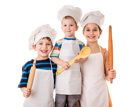 Three young smiling chefs standing together with ladle and rolling pin, isolated on white