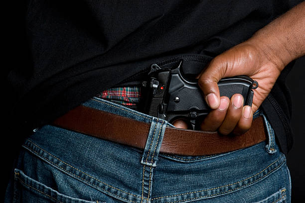 cartouche dans le pantalon - gun men holding handgun photos et images de collection