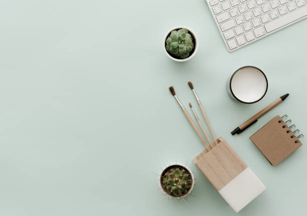 istock Minimalist Flat Lay Hipster Desktop With Keyboard, craft notebook, cactus and brushes 915075414