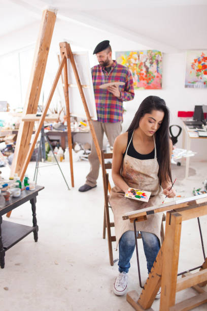 istock Couple painters drawing in workshop 915075528