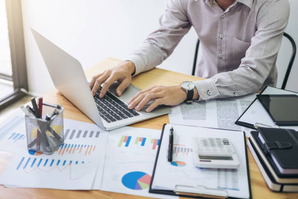 istock Image of business strategy, businessman working with laptop, tablet and financial document data graph on table in office 915079478