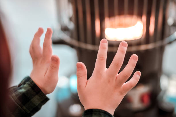 un garçon de réchauffement d’un incendie. - kerosene photos et images de collection