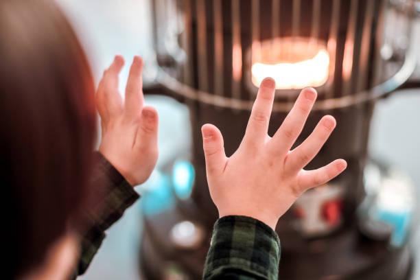 a boy warming a fire. - kerosene imagens e fotografias de stock