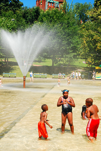 Boston, MA, USA August 10, 2011 Three children cool off during a warm summer day at the Frog Pond in Boston Common, Massachusetts