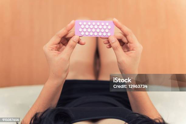 Photo libre de droit de Asiatique Femme Tenant Des Pilules Contraceptives Dans La Chambre À Coucher La Santé Et Le Concept Médical banque d'images et plus d'images libres de droit de Pilule contraceptive