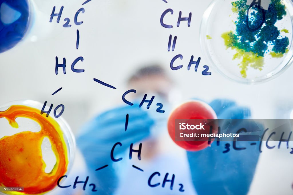 Chemical formulas with various substances Close-up of glassy board with chemical molecular formulas and colorful substances in petri dishes Chemistry Class Stock Photo