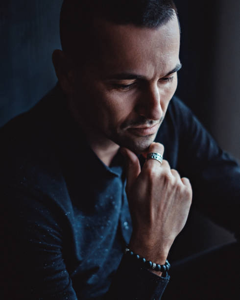 istock Sad man sitting by the window and thinking 915090470