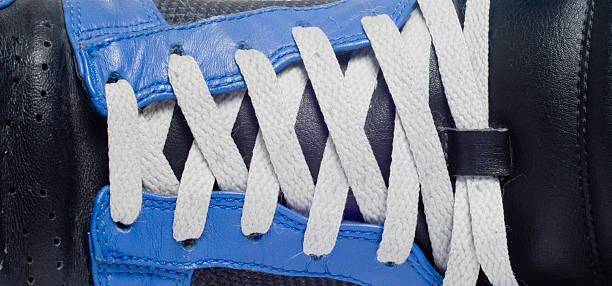 Atacadores em branco azul & Sapato preto - fotografia de stock