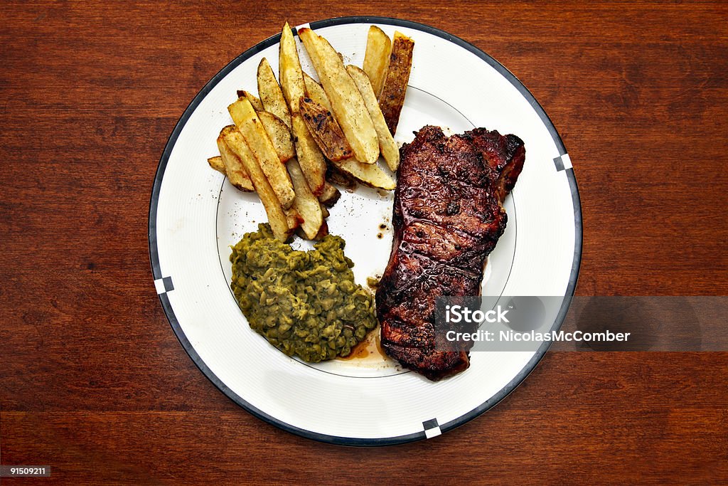 Bistecca di manzo con patatine fritte pasto e Purè di piselli - Foto stock royalty-free di Alla griglia