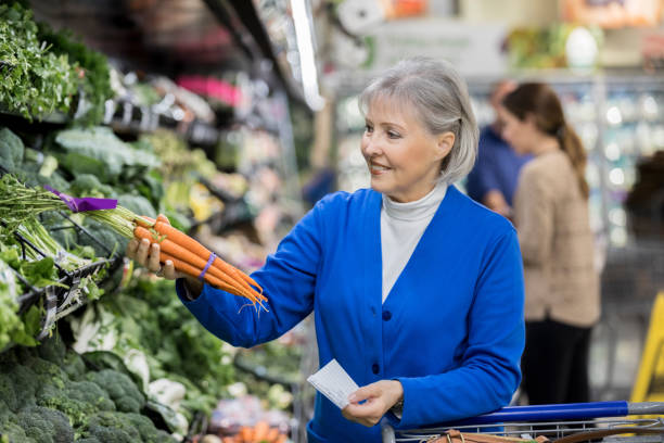 istock Senior woman selects organic carrots while shopping 915093090