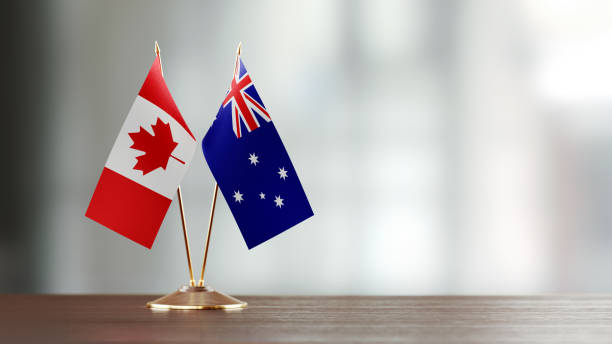 istock Australian And Canadian Flag Pair On A Desk Over Defocused Background 915093200