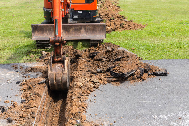 istock Digger machine operate for digging soil and repair road in the public park 915093890