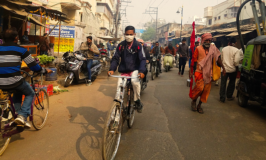 December 2017, Varanasi, India- Man on a bicycle wearing a protective mask due to air pollution in Varanasi.