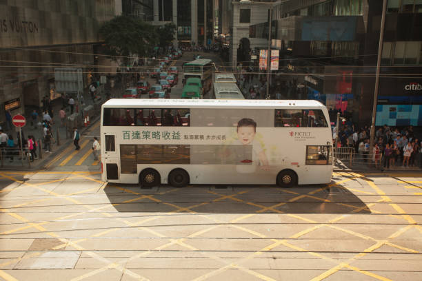 Hong Kong S.A.R., China - November 1, 2017;  everyday life; crowded city streets, daily commuters, cars and public transportation vehicles at narrow street crossing; Central island area;