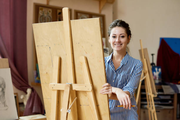 istock Happy talented artist drawing on easel 915106078