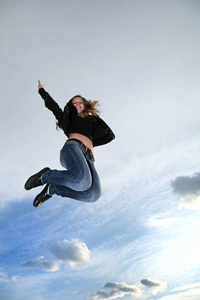 istock Happy young woman jumping against sky 91510967