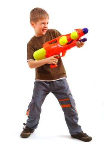 Young boy with water gun over white background.