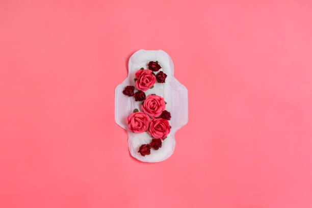 tampon sanitaire blanc avec des fleurs rouges et roses, femme santé ou corps concept positif. fond rose.  flatlay. surface - menstruation photos et images de collection